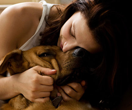 woman snuggling with dog